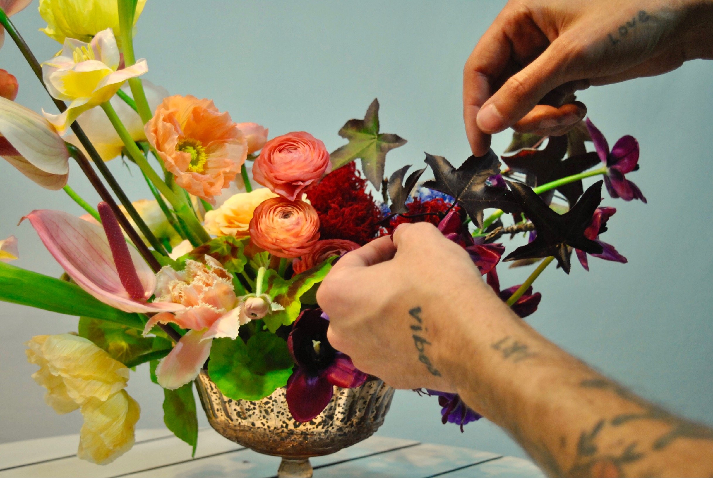 Designer placing a stem into a daring arrangement